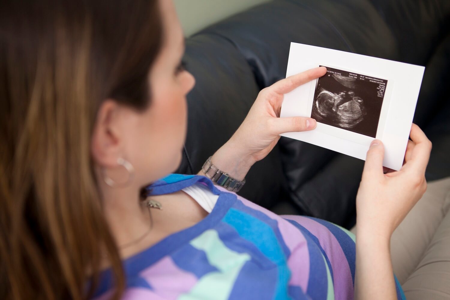 woman looking at an ultrasound of her baby