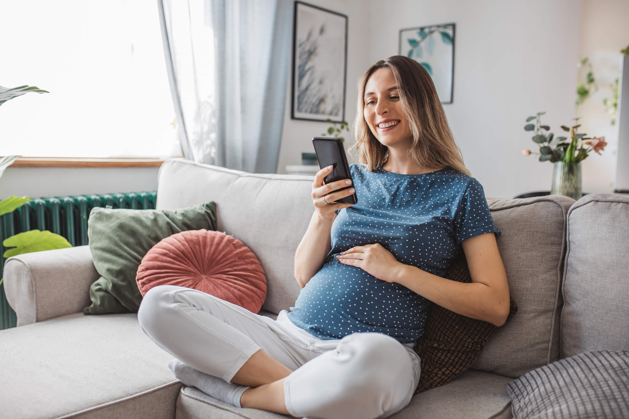 Pregnant women reads adoption information on her phone